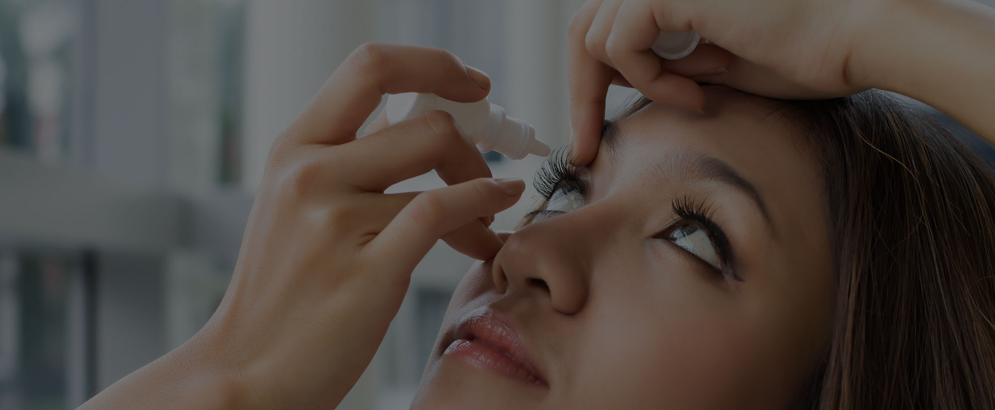 Woman putting in eye drops to relieve dry, irritated eyes